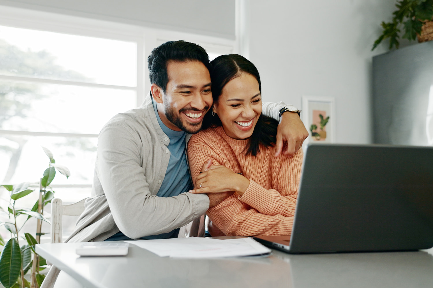 Pasangan suami istri menatap laptop - DOKU.Promo