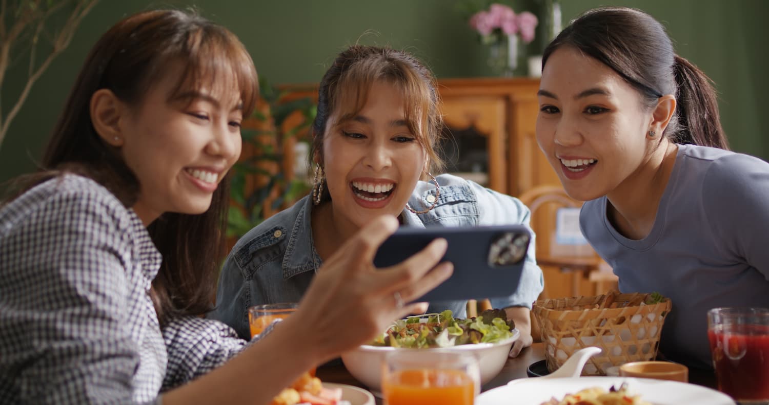 Sekelompok Wanita sedang Makan dan Melihat Hasil Konten Bersama - DOKU.Promo